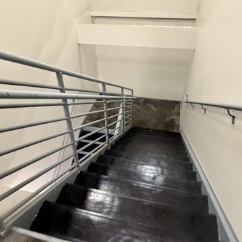 CVS Pharmacy - An indoor staircase with black, glossy steps and metal railings on both sides, leading downward in a building. - Drugstores Near Me - Austin, Texas
