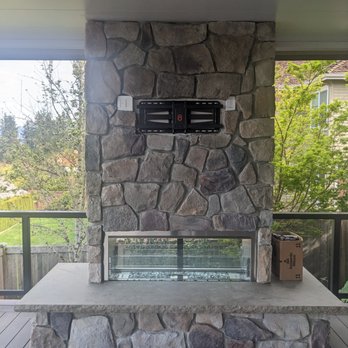 Reflections Landscape & Construction - a stone fireplace on a deck - Gardeners Near Me - Sammamish, Washington
