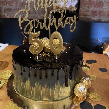 Sugartown Bakery Cafe - Custom cake for 50th birthday - yellow cake, chocolate filling, buttercream frosting black and gold w/ candy (topper & candles not incld) - Desserts Near Me - Jersey City, New Jersey