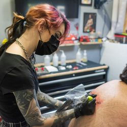 Tenku Tattoo - Samm working on a back tattoo in her station