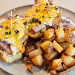 Roasted Nomad - Eggs Benny served on a fresh croissant from tall grass bakery! Rich house made hollandaise and house cut cubed hashbrowns! A fan fave!