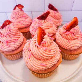 Koastal Kupcakes - a plate of cupcakes with pink frosting and strawberries - Cupcakes Near Me