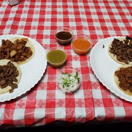two plates of tacos on a red and white checkered tablecloth two plates of tacos on a red and white checkered tablecloth