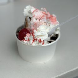 Vanilla soft serve with hot fudge, whipped cream, and a cherry on top
