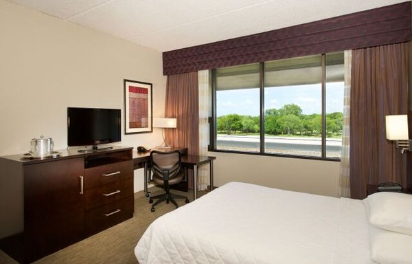 Photo of DexMedia - Dallas, TX, US. Contemporary furnishings include a flexible work space and lounge chair. Each room has a balcony with views of the landscaped grounds.