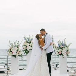 Between Flowers Design - White pillars at the altar at the beach
