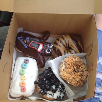 Voodoo Doughnut - Vegan Dirty (bottom) Vegan Gay Bar (left) Vegan Voodoo Doll (top left) Vegan peanut butter & chocolate (right) Butterfinger - Donuts Near Me - Denver, Colorado