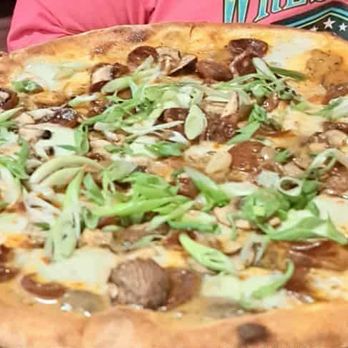 Reno - Spanish Pizza - A large pizza with sausage, mushrooms, and green onions as toppings, served on a metal tray. - American Near Me - Chicago, Illinois