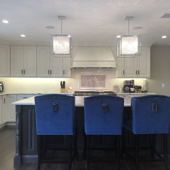 Tarr's Home Improvements - a kitchen with white cabinets and blue chairs - General Contractors Near Me - Franklin Square, New York Tarr's Home Improvements - a kitchen with white cabinets and blue chairs - General Contractors Near Me - Franklin Square, New York