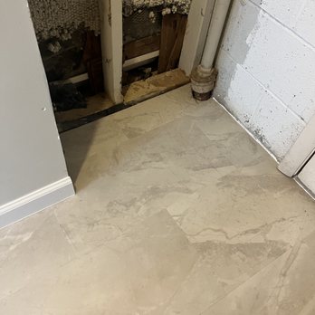 Absolute Flooring - Floor in utility closet. LVP tiles cut around the pipe in the corner. - Flooring Near Me - Woodbridge, Virginia
