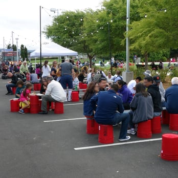 Moveable Feast - a large group of people sitting on red barrels - Food Trucks Near Me - San Mateo, California