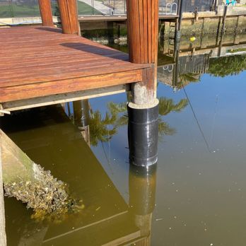 Anchor Seawall - a wooden dock with a pole sticking out of the water - General Contractors Near Me