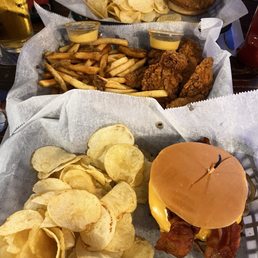 Burger with chips forefront Chicken tenders and fries middle Tenderloin sandwich with chips background Burger with chips forefront Chicken tenders and fries middle Tenderloin sandwich with chips background