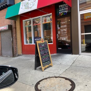 Taco Town - Taco Town's exterior features a red and green awning, a menu board on the sidewalk, and a glass door with business hours and contact info. - Mexican Near Me - Baltimore, Maryland