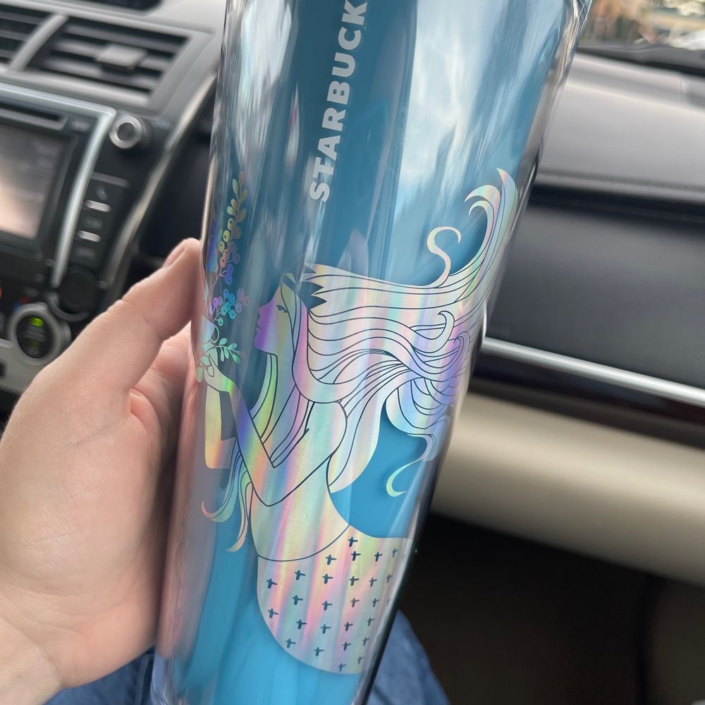 a person holding a cup in a car