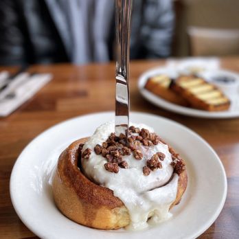 Cafe Flora - Cinnamon Roll | cream cheese frosting & maple toasted pecans - Vegetarian Near Me - Seattle, Washington Cafe Flora - Cinnamon Roll | cream cheese frosting & maple toasted pecans - Vegetarian Near Me - Seattle, Washington