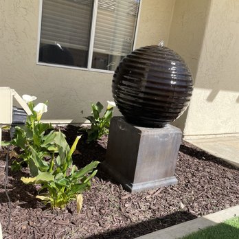 Helcco Landscape Construction - Fountain installation surrounded by calla lilies and new bark with drip irrigation - Landscaping Near Me