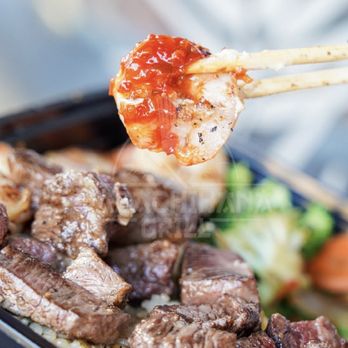 Habachihana Japanese Grill - a person holding chopsticks over a tray of food - Japanese Near Me - Anaheim, California Habachihana Japanese Grill - a person holding chopsticks over a tray of food - Japanese Near Me - Anaheim, California