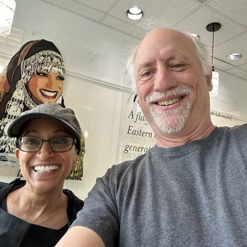 The Ma'lawah Bar - I'm standing with Doreet, the proprietor of Ma'lawah, in front of a photo of a woman in traditional Yemenite dress. - Wraps Near Me - Palo Alto, California