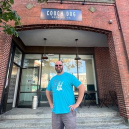 a man standing in front of a brick building