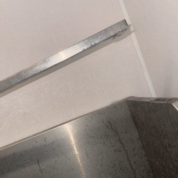 Tractor Supply - Broken equipment - A metal tool, possibly a level, is mounted on a white wall above a stainless steel countertop or sink. - Pet Stores Near Me - Wappingers Falls, New York