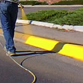 Alternative Striping - a man using a hose to clean a street - General Contractors Near Me Alternative Striping - a man using a hose to clean a street - General Contractors Near Me