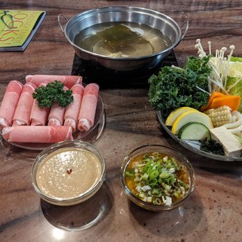 Tadaima Shabu Shabu - Clockwise from 12:00:  individual broth for cooking, veggie plate, dipping sauces soy and sesame, raw pork belly. - Japanese Near Me - Reno, Nevada