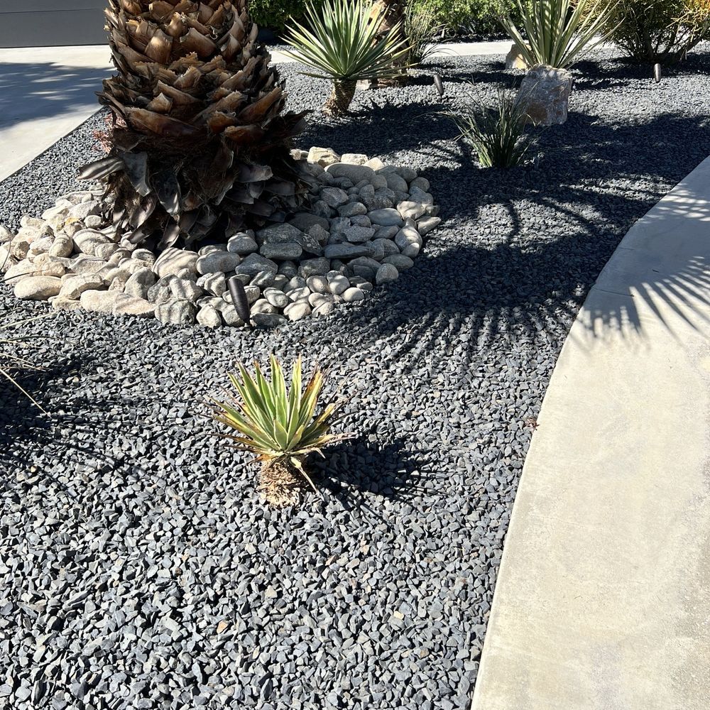 They cleaned out the old dirty rocks, trimmed the plants and put down new weed barrier and put down the new rocks.