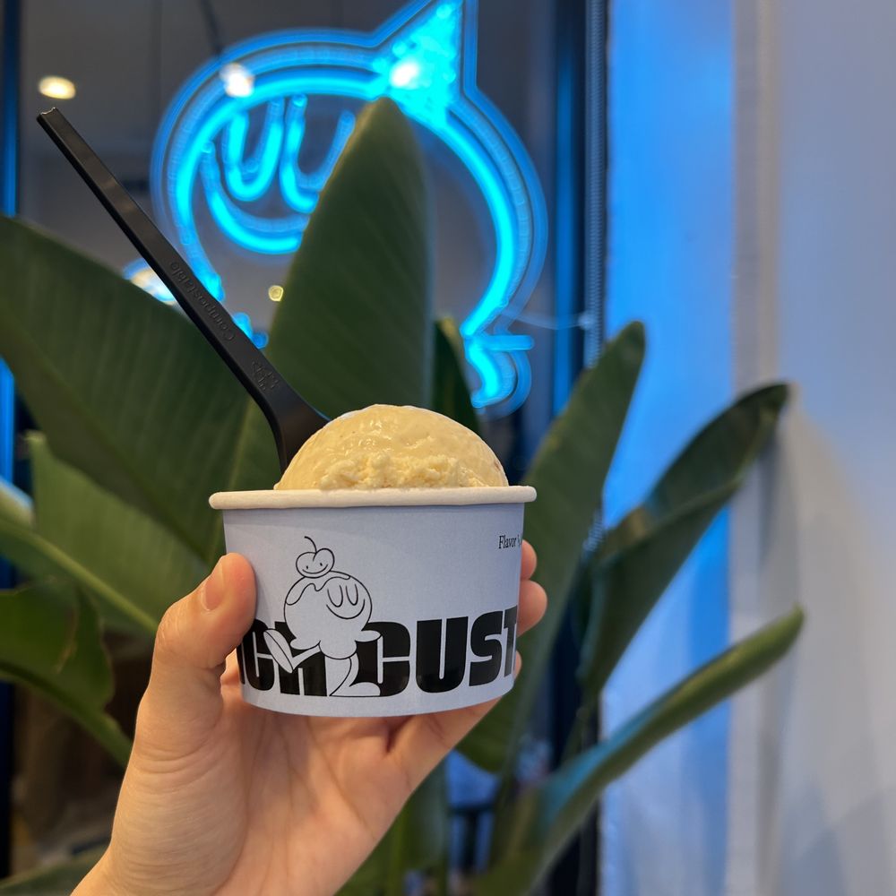 a hand holding a cup of ice cream