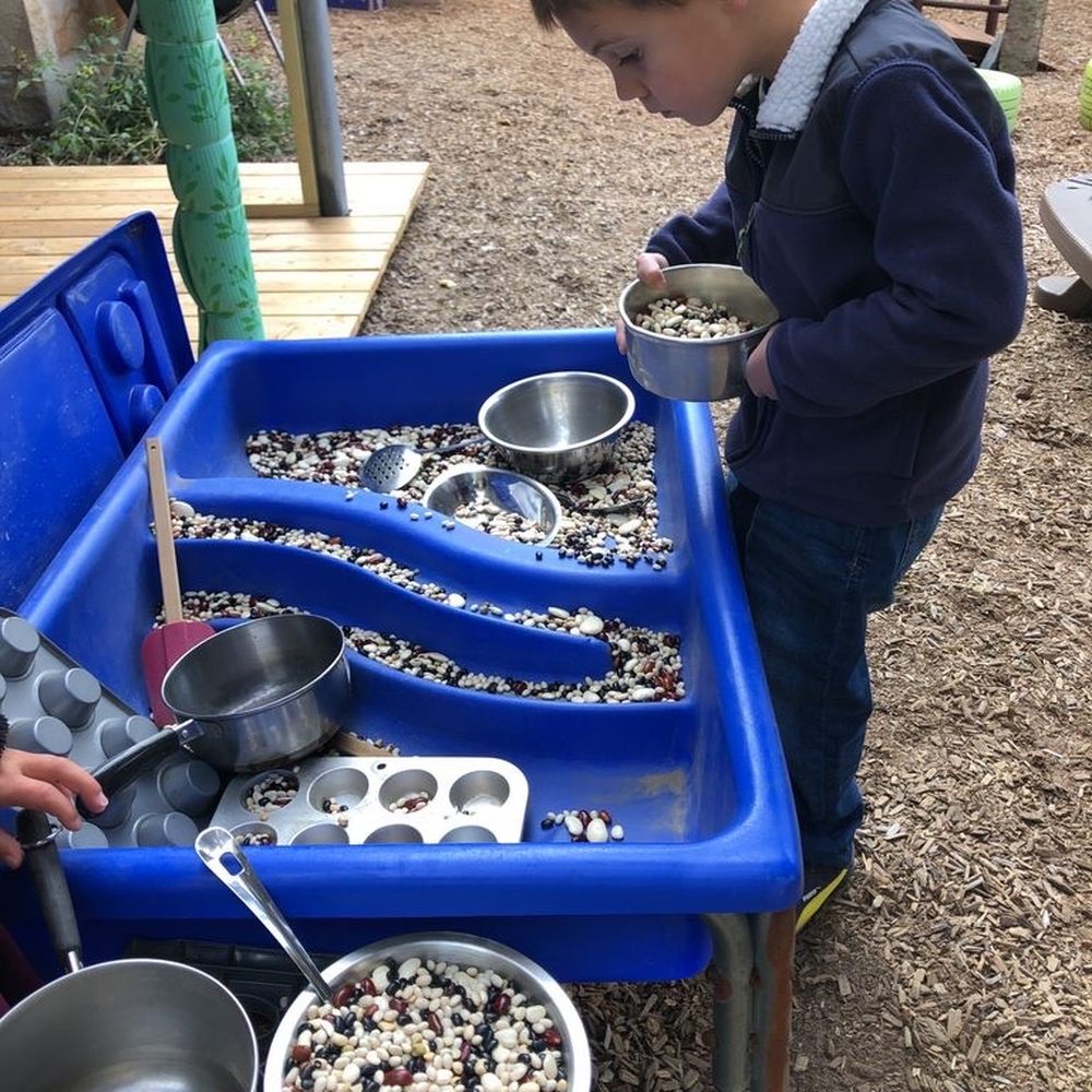 East Side Nursery School - Playing in the sensory table w beans. - Preschools Near Me - Providence, Rhode Island East Side Nursery School - Playing in the sensory table w beans. - Preschools Near Me - Providence, Rhode Island