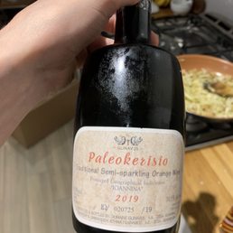 a hand holding a bottle of wine