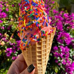 Strawberry soft serve in a waffle cone with sprinkles Strawberry soft serve in a waffle cone with sprinkles