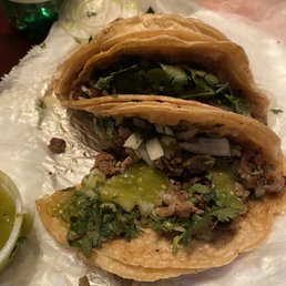 Carne asada taco with cilantro, onions, and salsa verde.