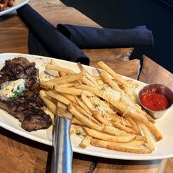 Medium rare steak with a side of fries