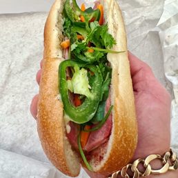 a hand holding a sub sandwich a hand holding a sub sandwich