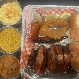 Bbq, sausage, and catfish! Potato salad, corn and yams and rolls.