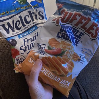 7-Eleven - a person holding a bag of waffles and a bag of chips - Convenience Stores Near Me - Dallas, Texas