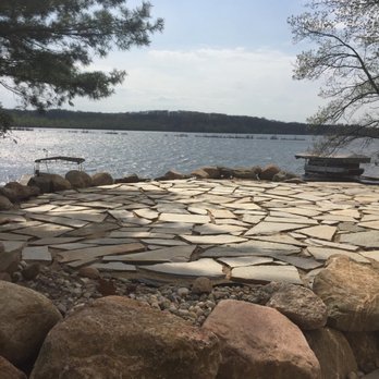 Quicklawn Hydroseeding - a stone patio next to a lake - Snow Removal Near Me - Cadillac, Michigan