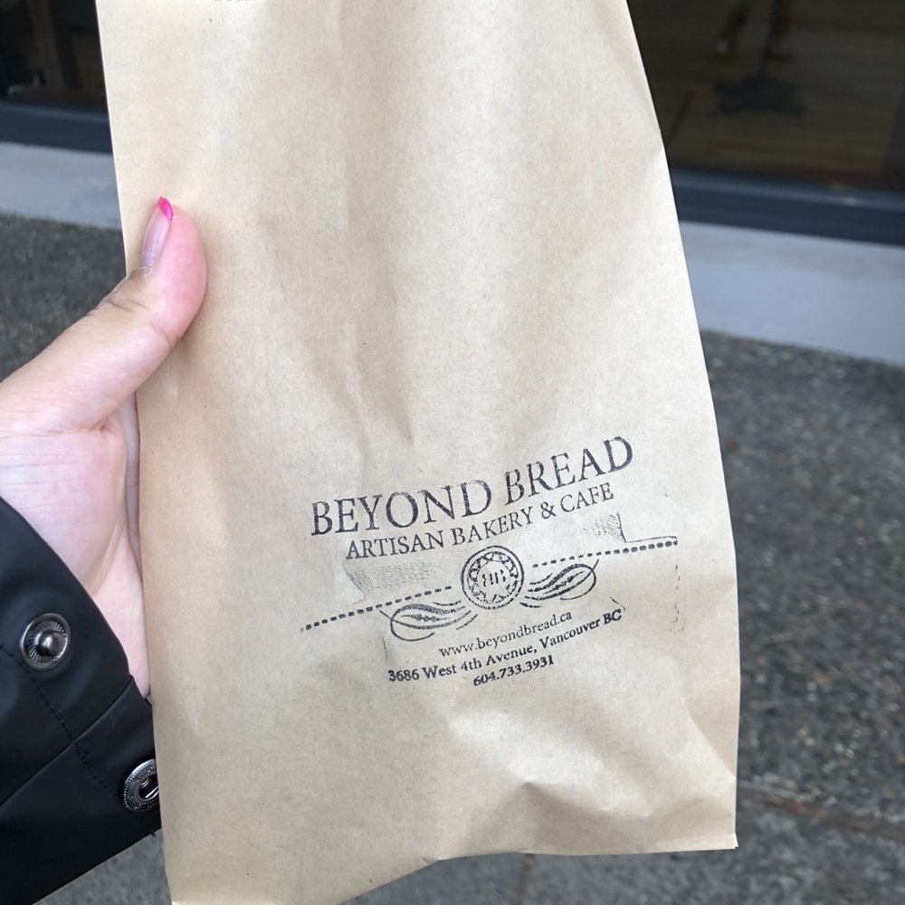 Beyond Bread Artisan Bakery - a hand holding a bag of bread - Bakeries Near Me - Vancouver, British Columbia Beyond Bread Artisan Bakery - a hand holding a bag of bread - Bakeries Near Me - Vancouver, British Columbia