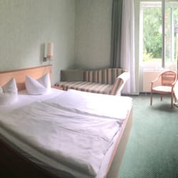 Atrium Hotel Krüger - Großzügiges Zimmer mit großem Doppelbett, Flat-TV und Minibar