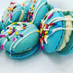 Birthday cake macarons with a cake batter filling topped with white chocolate and sprinkles.