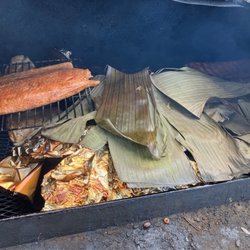 Austin Barbecue Company Catering - A salmon fillet and a whole pig wrapped in banana leaves smoke roast on the big pit for a South Austin company party last December 2022,