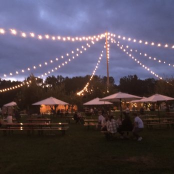 Westwind Orchard - people sitting at picnic tables under string lights - Cideries Near Me - Accord, New York