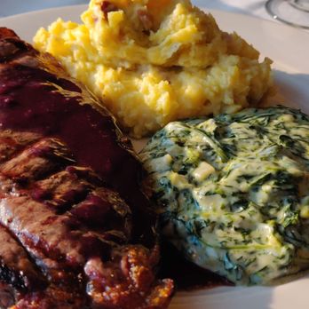 Mural Room - Bison ribeye with yukon mashed potato and manchego creamed spinach and huckleberry demiglace - American Near Me - Moran, Wyoming