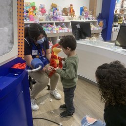 A build a bear employee showing my son where the sound button is on his stuffed Dino and how to press it to hear the sound. A build a bear employee showing my son where the sound button is on his stuffed Dino and how to press it to hear the sound.