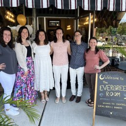 a group of women standing in front of a restaurant