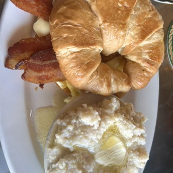 Hive Cafe - Bacon, egg, and cheese on a croissant with a side of grits. - Breakfast & Brunch Near Me - Ferguson, Missouri