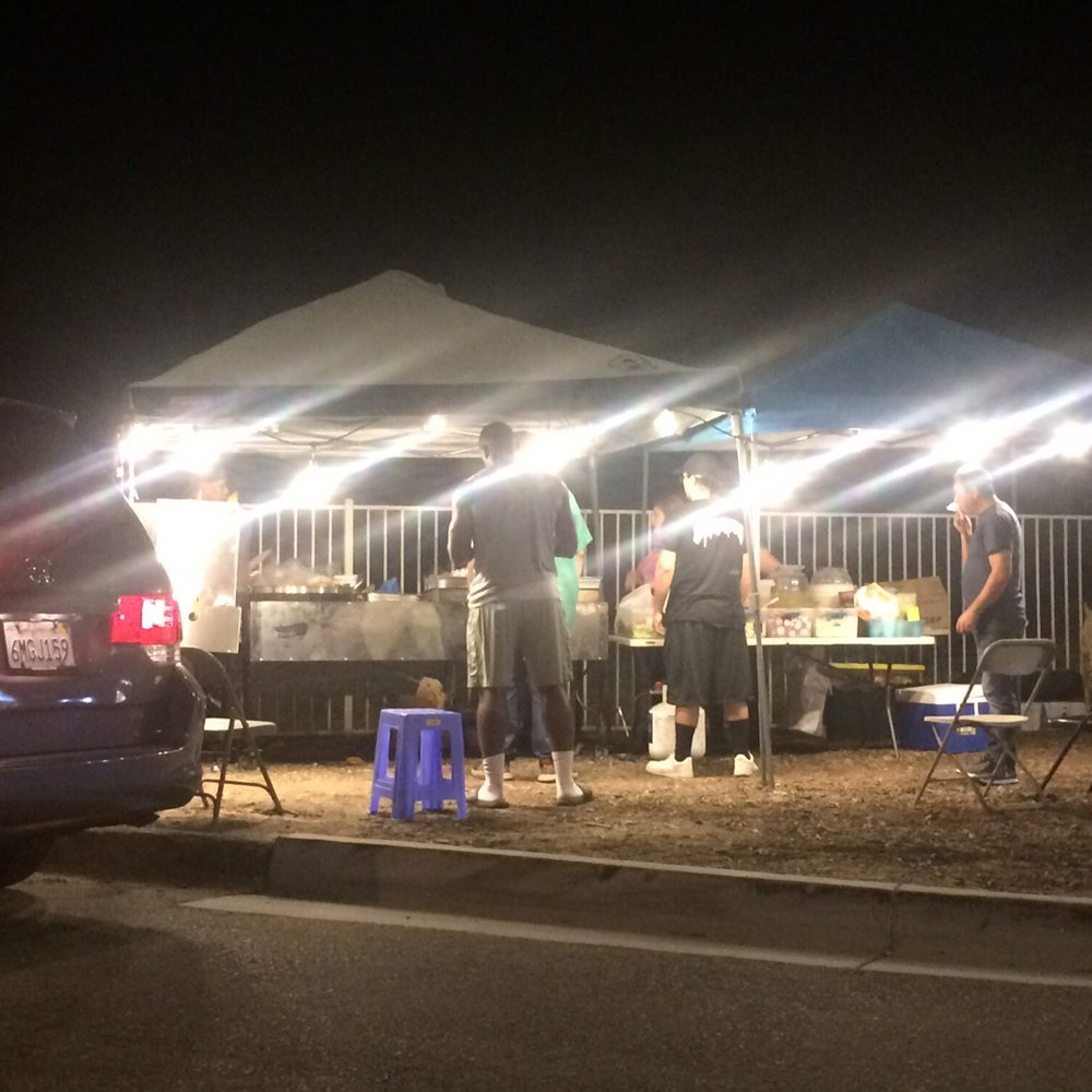 Tons O’ Topping Tacos -  a food stand at night - Tacos Near Me