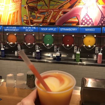 Wet Willie's - A small AC sunset (mango, pina colada and strawberry). $10. On the left behind my hand are 3 different size cups. - Cocktail Bars Near Me - Atlantic City, New Jersey