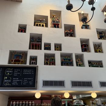 Coronet Cafe - Inside - Miniature colorful castles are arranged in wall niches above the cafe counter, with a menu board and lighting fixtures visible. - Cafes Near Me - Tucson, Arizona